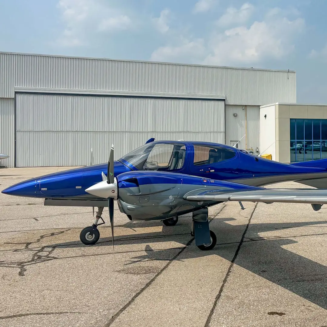 Blue twin-engine piston aircraft positioned on the tarmac for training and travel