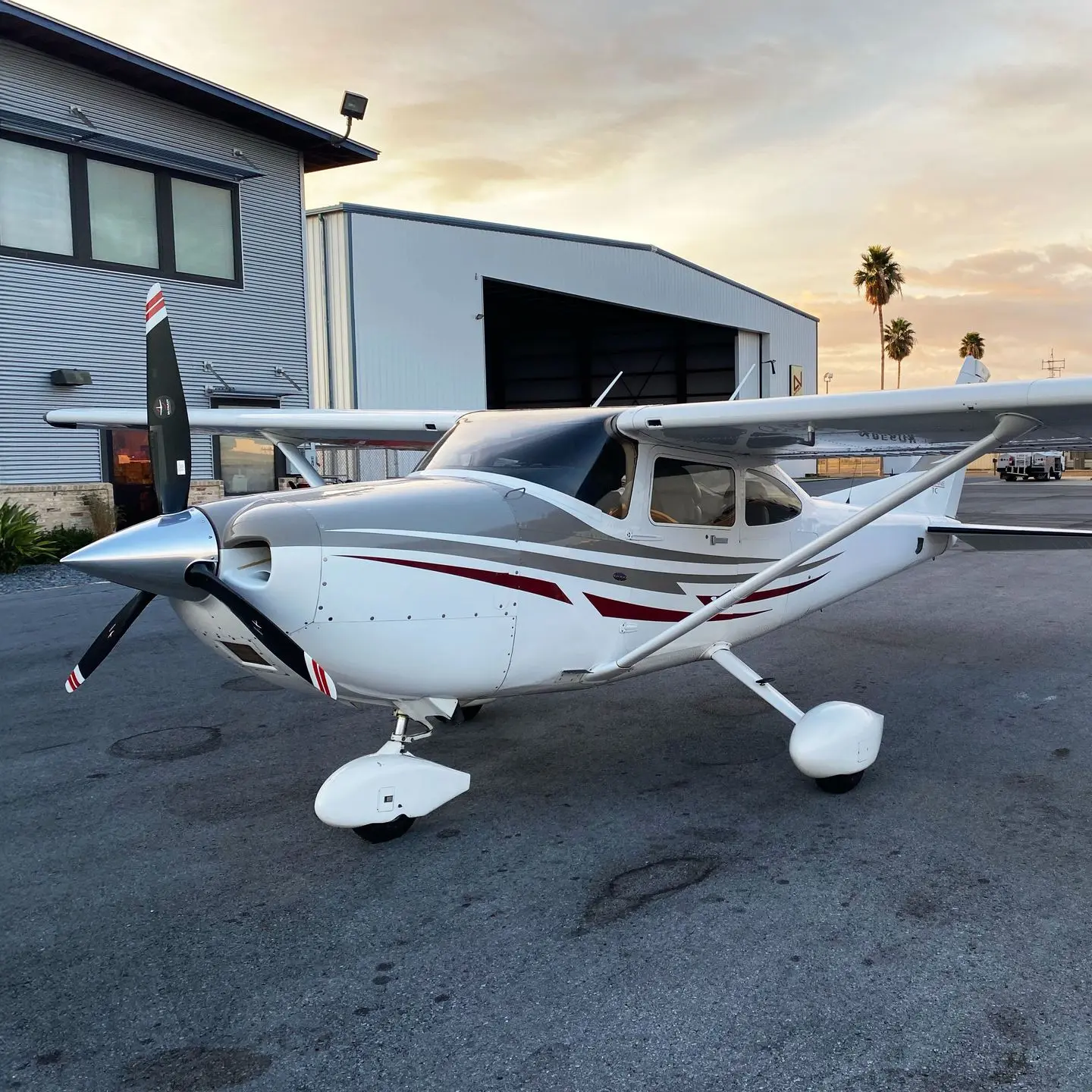Pre-owned white piston aircraft with proven flight history outside hangar